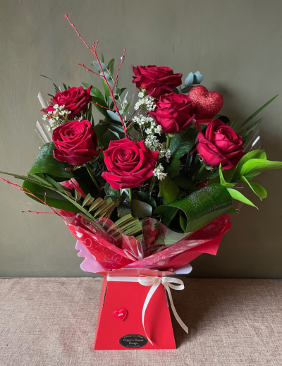 Poppy's Flower Design Florist in Leyland - Kissing Booth - Half dozen premium red roses arrange in luscious mixed foliage, completed with a beautiful heart shaped pick.